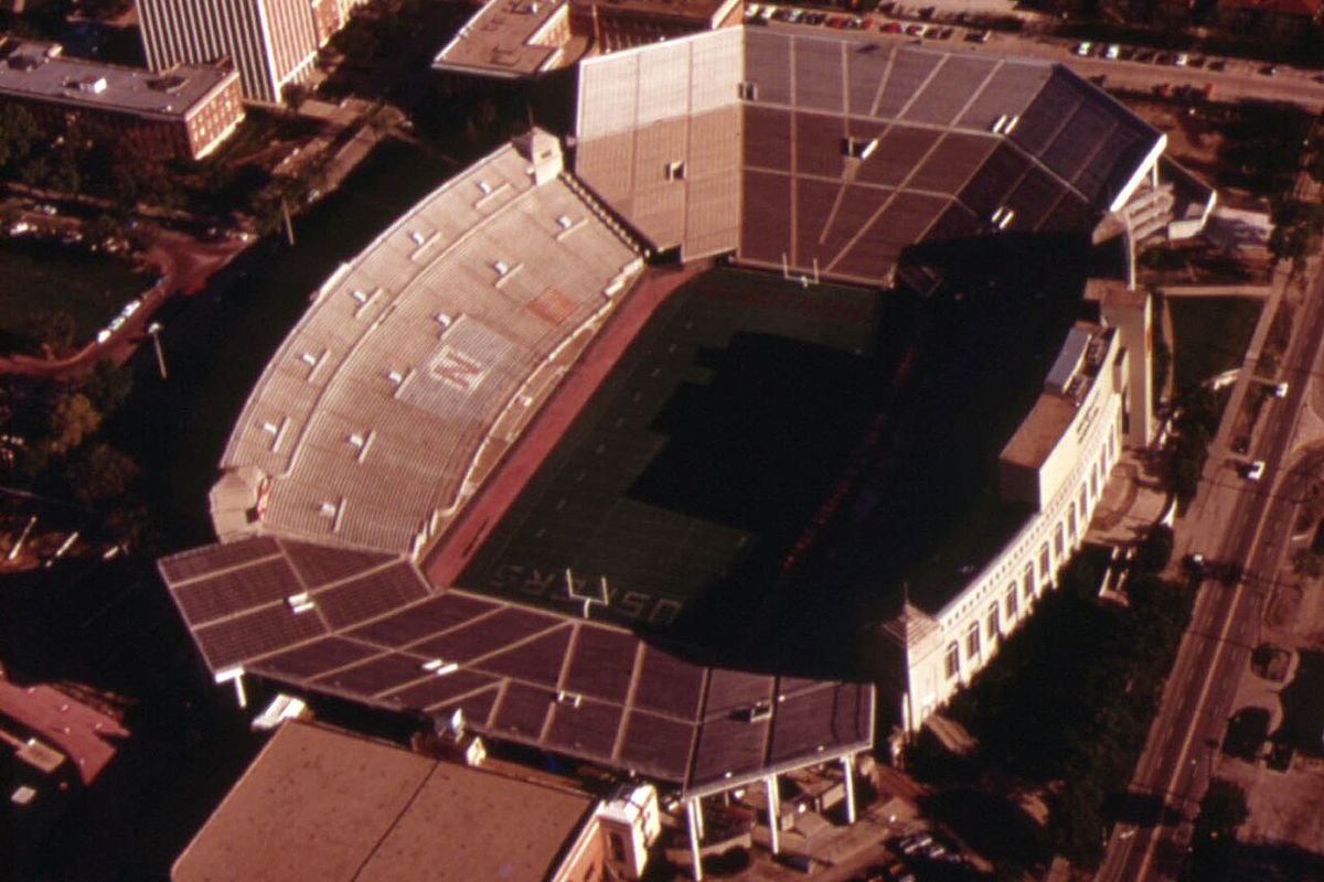 Aerial photo of Nebraska's Memorial Stadium in Lincoln in 1973, a horseshoe of stands around a green field.