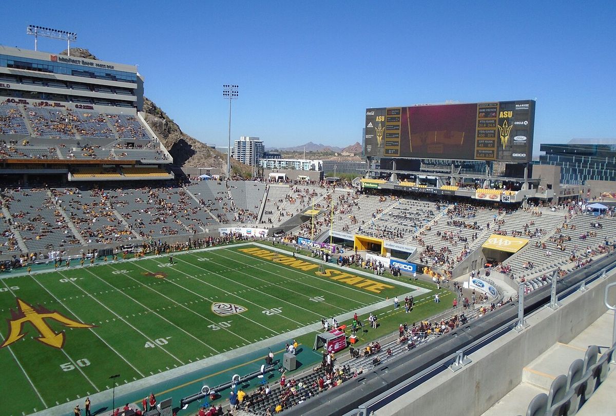 Inside Arizona State's Sun Devil Stadium on a sunny day, with desert hills behind the stands.